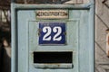 Old houseÃ¢â¬â¢s metal aged door with mailbox and sign 22 number, and text Ã¢â¬Åhouse managerÃ¢â¬Â, urban concept, green door